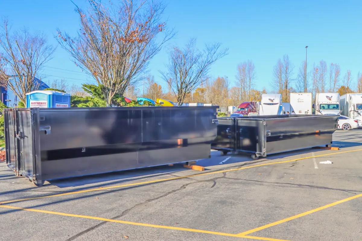 Professional dumpster rental service with roll-off container on residential driveway in Woodcrest